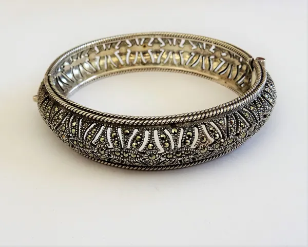A silver and marcasite set circular hinged bangle, having pierced decoration within twin wirework borders, on a snap clasp, detailed 925, gross weight