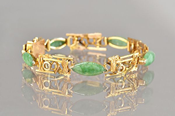 A gold and jade bracelet, the links in a rectangular openwork abstract design, with a textured finish, mounted with five marquise shaped jades at inte