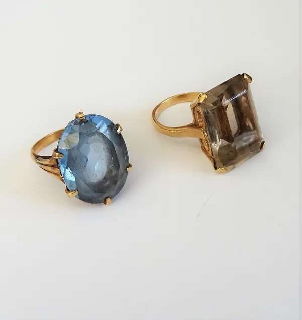 A 9ct gold ring, claw set with a cut cornered rectangular step cut smoky quartz, London 1967, ring size L and a half and a 9ct gold and oval cut blue
