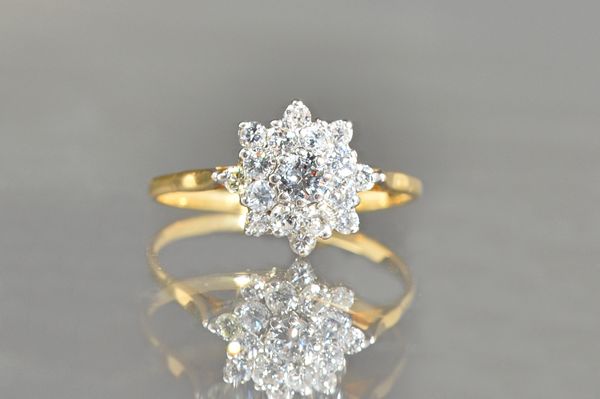 An 18ct gold and diamond cluster ring, claw set with the principal circular cut diamond to the centre, in a two tier surround, claw set with smaller c