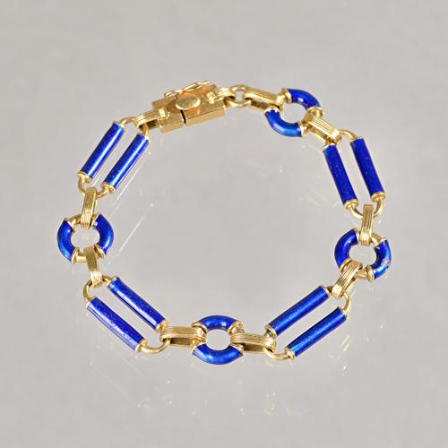 A gold and blue enamelled bracelet, in a circular and bar link design, on a snap clasp, detailed 750, gross weight 29.5 gms. Illustrated.