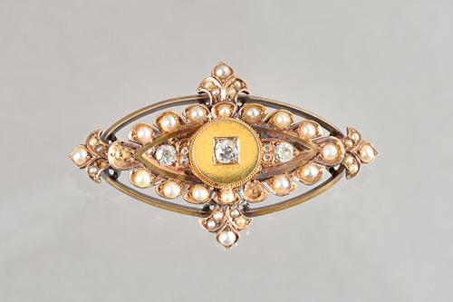 A late Victorian gold, diamond and half pearl set brooch, of shaped oval form, mounted with the principal cushion shaped diamond to the centre, within