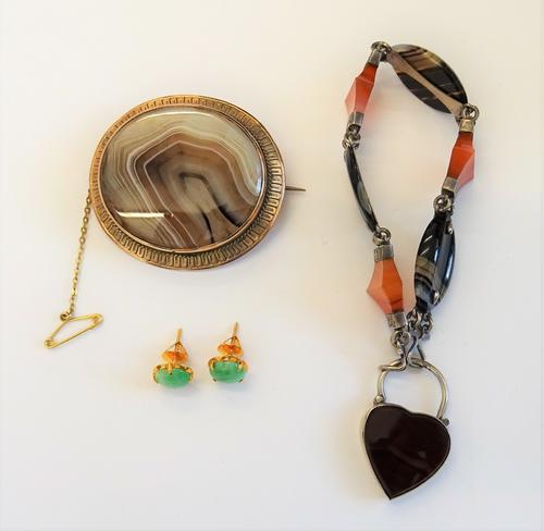 A pair of gold and jade single stone earstuds, each mounted with a circular jade, with a case, a gold mounted oval banded agate brooch, detailed 9 T.W