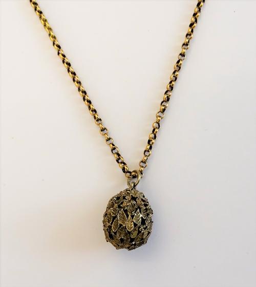 A Stuart Devlin, silver gilt egg shaped pendant, with foliate decoration, London 1987, with a gold circular link neckchain, on a boltring clasp, weigh