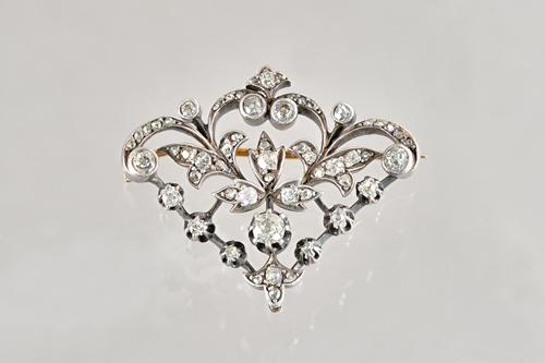 A European diamond brooch, possilby French, in a pierced foliate design, mounted with cushion shaped and rose cut diamonds, width 3.8cm, with a box. I