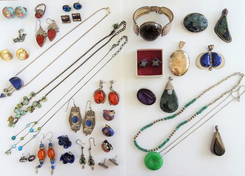 A group of silver and costume jewellery, comprising; a reconstituted amber bangle, an oval pendant locket, five further pendants , a ring, two brooche