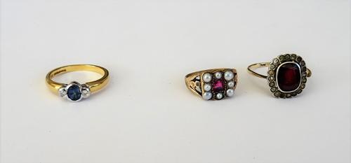 An 18ct gold, sapphire and diamond three stone ring, collet set with the oval cut sapphire at the centre, between two circular cut diamonds, ring size