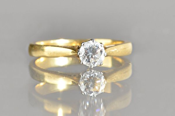 An 18ct gold and diamond single stone ring, claw set with a circular cut diamond, ring size M, gross weight 3.4 gms. Illustrated.