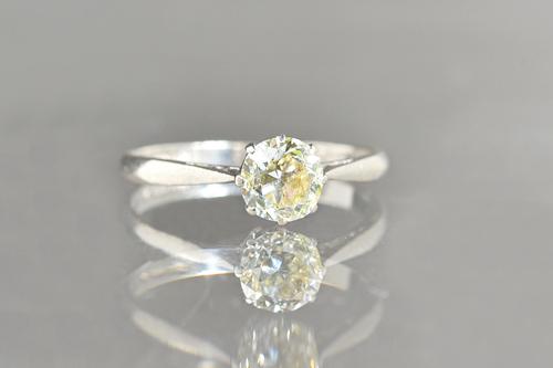 A platinum and diamond set single stone ring, claw set with a cushion shaped diamond, the shank detailed Platinum, ring size O and a half, with a case