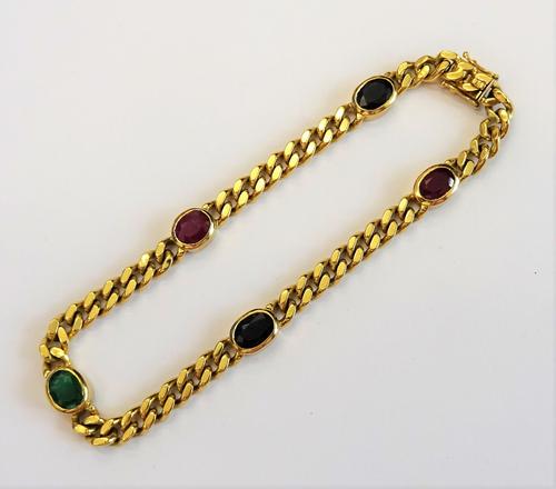 A gold, ruby, sapphire and emerald set faceted curb link bracelet, the bracelet links spaced with two oval cut rubies, two oval cut sapphires and with