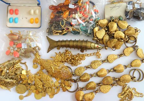 A large collection of costume jewellery, including; bead and other necklaces, gilt metal jewellery designed as fish and seashells, brooches, including