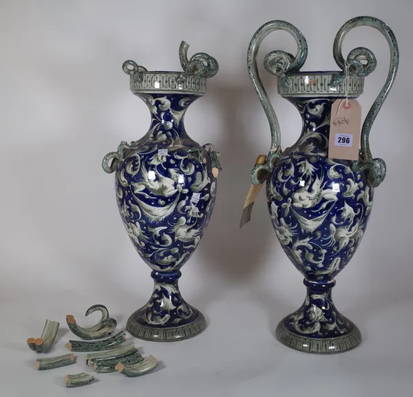 A pair of blue and white vases, with twin serpent handles in the 18th century Italian style, 66cm high, (a.f.).