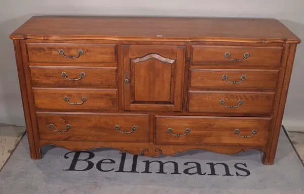 A 20th century hardwood serpentine dresser with cupboard doors flanked by four drawers on cabriole supports, 174cm wide x 91cm high.