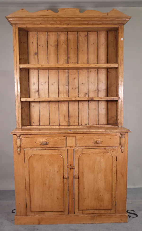 An early 20th century pine dresser with two tier plate rack over two drawers and cupboard base, 108cm wide x 200cm high.