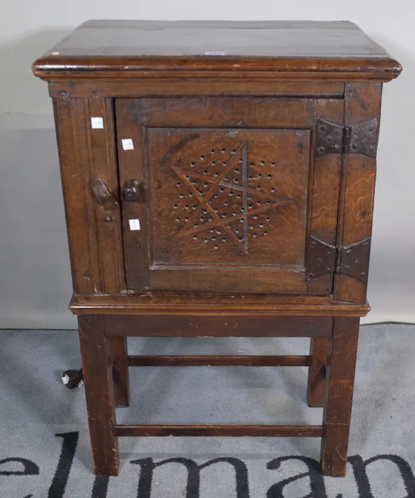 A 17th century and later oak single door food cupboard on stand, 57cm wide x 84cm high.