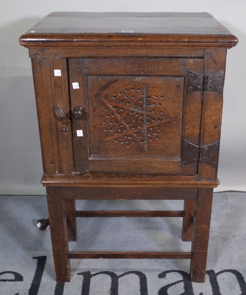 A 17th century and later oak single door food cupboard on stand, 57cm wide x 84cm high.