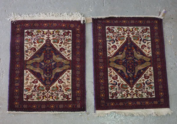 A pair of Baluchistan mats, each with an indigo field with four birds, ivory floral vase spandrels, 94cm x 67cm , (2).