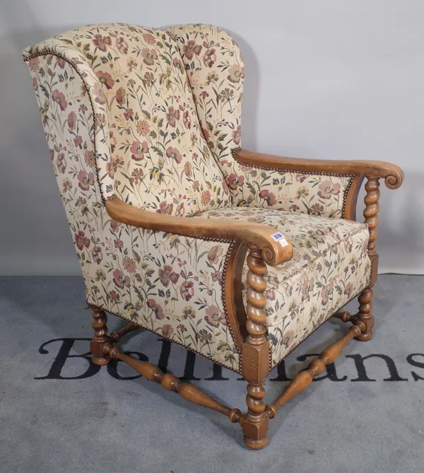 A 19th century floral upholstered wingback armchair on barley-twist supports, 74cm wide x 101cm high.