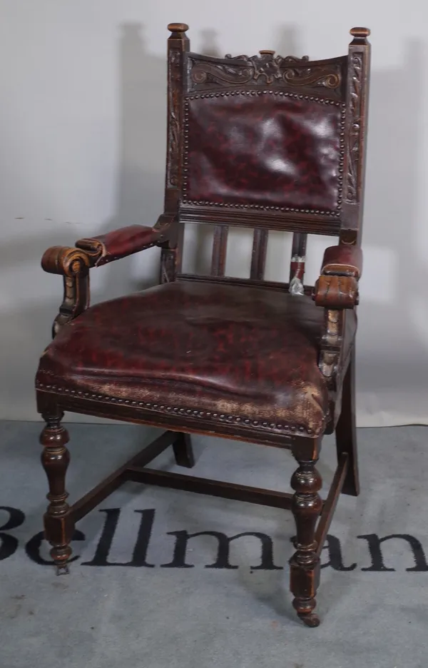 An early 20th century oak open armchair with faux leather back and seat.