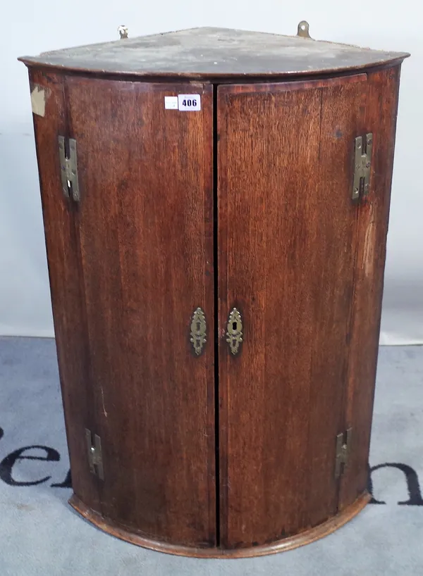 An 18th century oak bowfront hanging corner cupboard, 61cm wide x 89cm high.