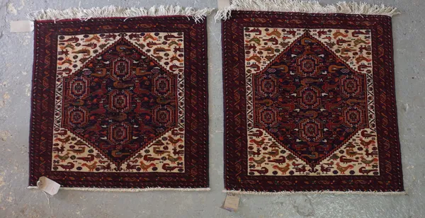 A pair of Baluchistan mats, with seven guls, ivory and bird spandrels, 76cm sq, (2).