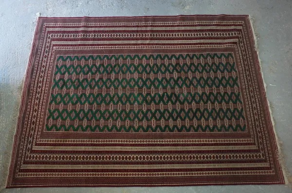 A Turkman carpet, the sage field with five columns of connecting guls, multi borders, 328cm x 248cm.