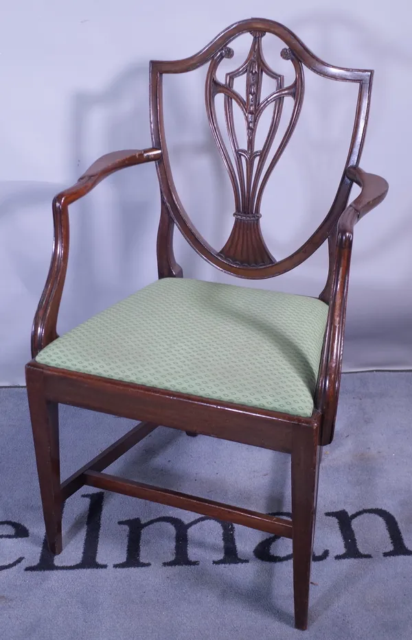 A late 18th century mahogany shield back carved chair on tapering square supports, 59cm wide x 98cm high.