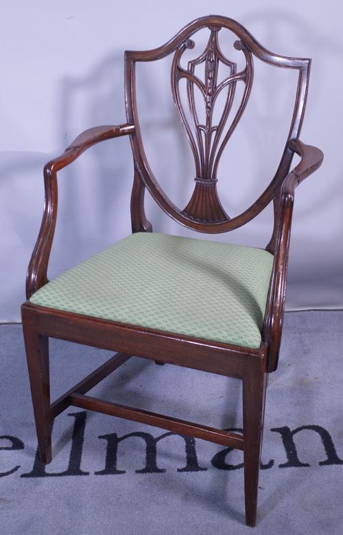 A late 18th century mahogany shield back carved chair on tapering square supports, 59cm wide x 98cm high.
