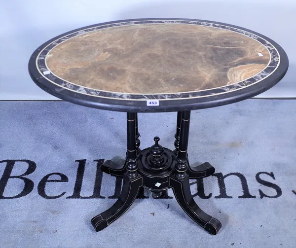 A Victorian oval centre table, the onyx and slate top over ebonised and parcel gilt base, on four outswept supports, 81cm wide x 71cm high.