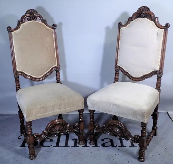 A pair of 19th century carved oak hall chairs of 17th century Continental design, on block and turned supports, 57cm wide x 124cm high (2).