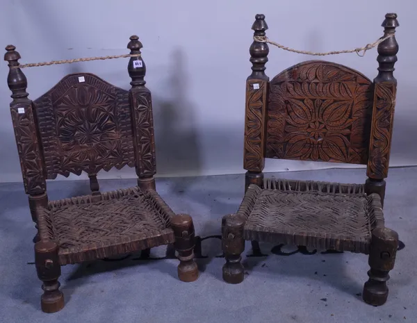 A pair of late 19th century Pakistan Swat Valley carved hardwood low chairs, on turned supports, 49cm wide x 70cm high (2).