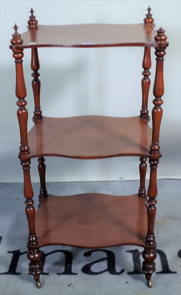 A Victorian mahogany three tier what-not, of serpentine outline, on turned supports, 42cm wide x 86cm high.