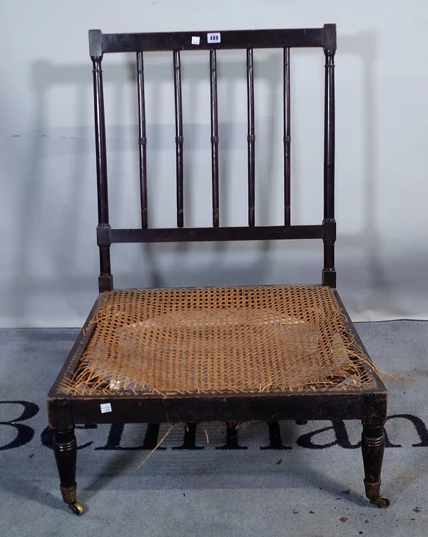 An early 19th century oak framed low side chair, with railed back on tapering turned supports.