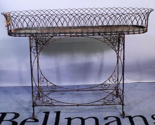 An early 20th century wirework oval planter, 105cm wide x 76cm high, and a pair of early 20th century black painted metal faux bamboo planters, 30cm w