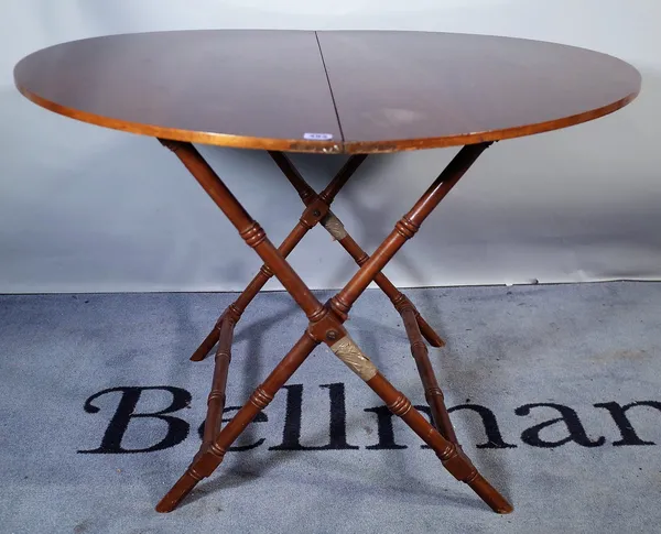 A 20th century mahogany folding circular coaching table, on ring turned supports, 97cm wide x 67cm high.