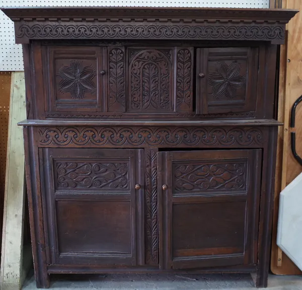 A 17th century and later carved oak court cupboard, with a pair of small cupboards over a larger, 150cm wide x 157cm high.