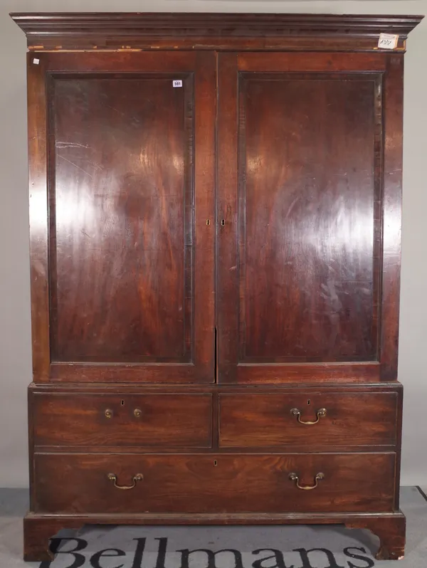 A George III mahogany linen press, with a pair of doors over two short and one long drawer, on bracket feet, 141cm wide x 196cm high.