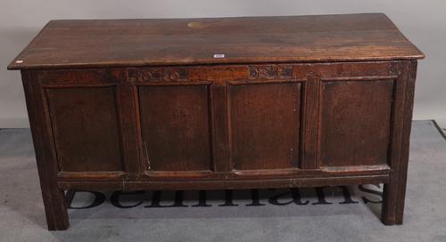 A 17th century oak coffer with plank top and four panel front, dated 1676, 128cm wide x 62cm high.