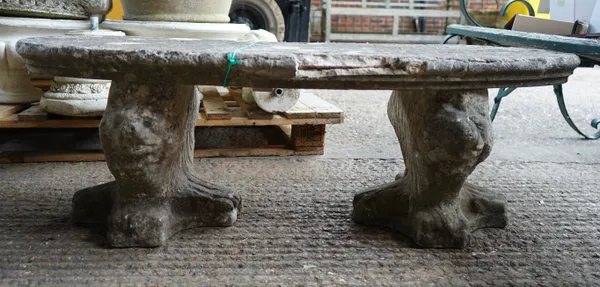 A 20th century curved composition stone bench, on lion pedestal bases, 120cm wide x 39cm high.