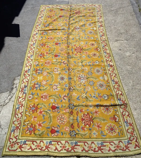 A large decorative carpet, probably Spanish or possibly Turkish, with mustard yellow ground and polychrome decoration, 578cm x 260cm.