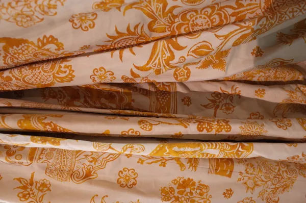 Two pairs of lined and interlined cream curtains with a yellow floral pattern, the larger 110cm wide x 290cm long, the other 84cm wide x 217cm long, (