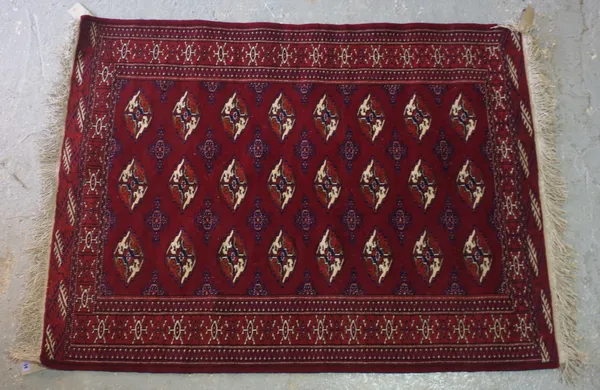 A Turkman rug, the madder field with three columns of eight guls, a sunburst border, skirt ends, 161cm x 123cm.