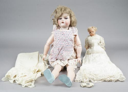 A Kammer and Reinhardt bisque head porcelain doll, circa. 1910, with sleep eyes, open mouth and jointed limbs, mould No 68, 74cm and a smaller early 2
