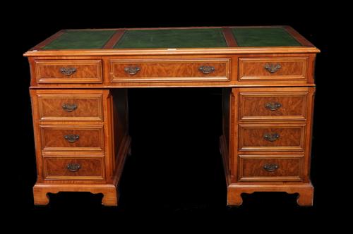 A modern walnut and stained beech pedestal desk with nine drawers and green leather inset top, 138cm wide x 73cm high.