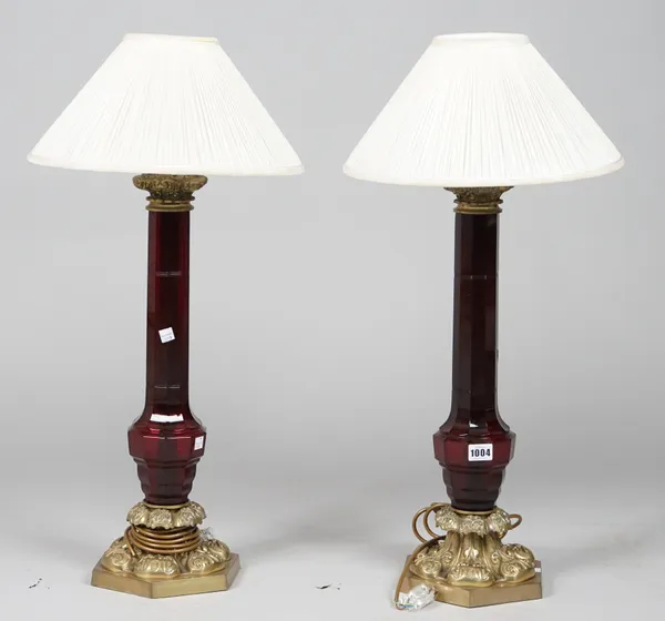 A pair of modern ruby glass and gilt metal table lamps, each of Victorian style on a hexagonal base, 55cm high, (2).