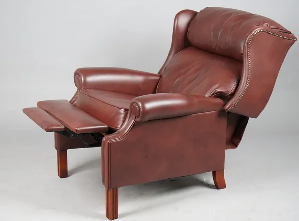 A modern hardwood framed and brown leatherette upholstered reclining wingback armchair, 87cm wide x 104cm high.