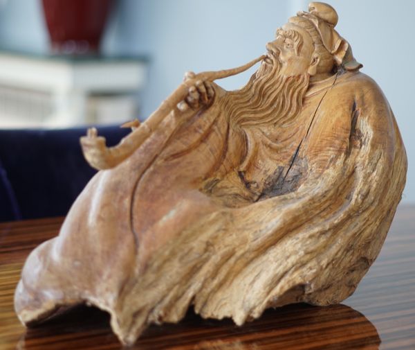 A Japanese rootwood carving of a recumbent man, 60cm long, 40cm high.