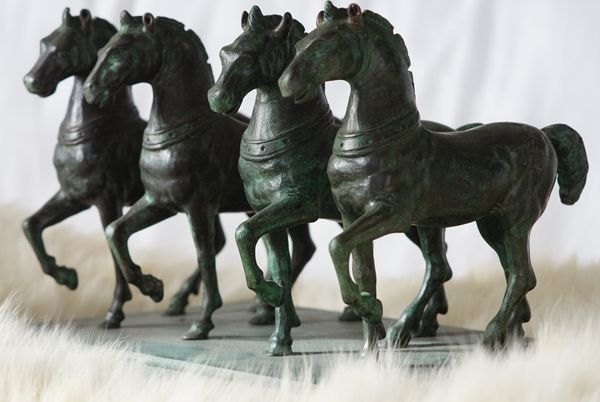 A patinated bronze equestrian group of four horses, 16cm high.
