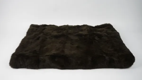 A dark brown fur throw, 180cm x 124cm.