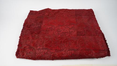 A dark red faux fur throw with pierced foliate pattern, approx. 254cm x330cm.